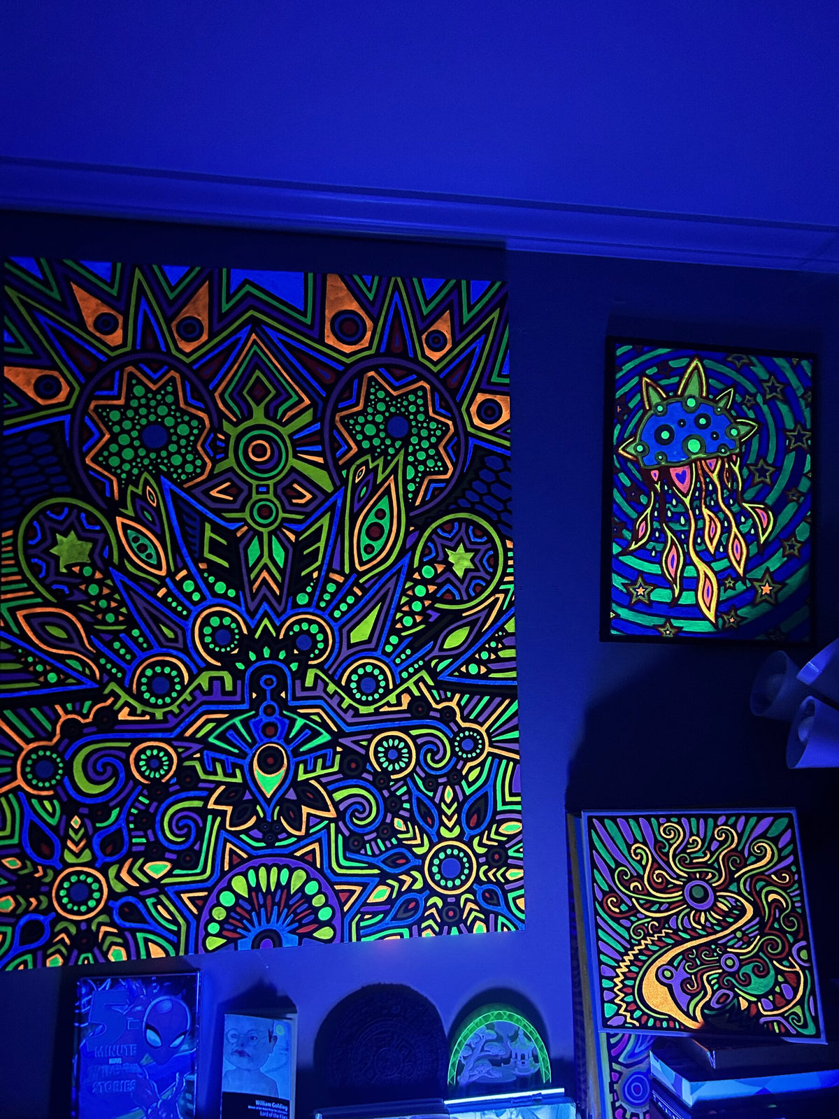 Fluorescent paintings glowing under blacklight at a show
